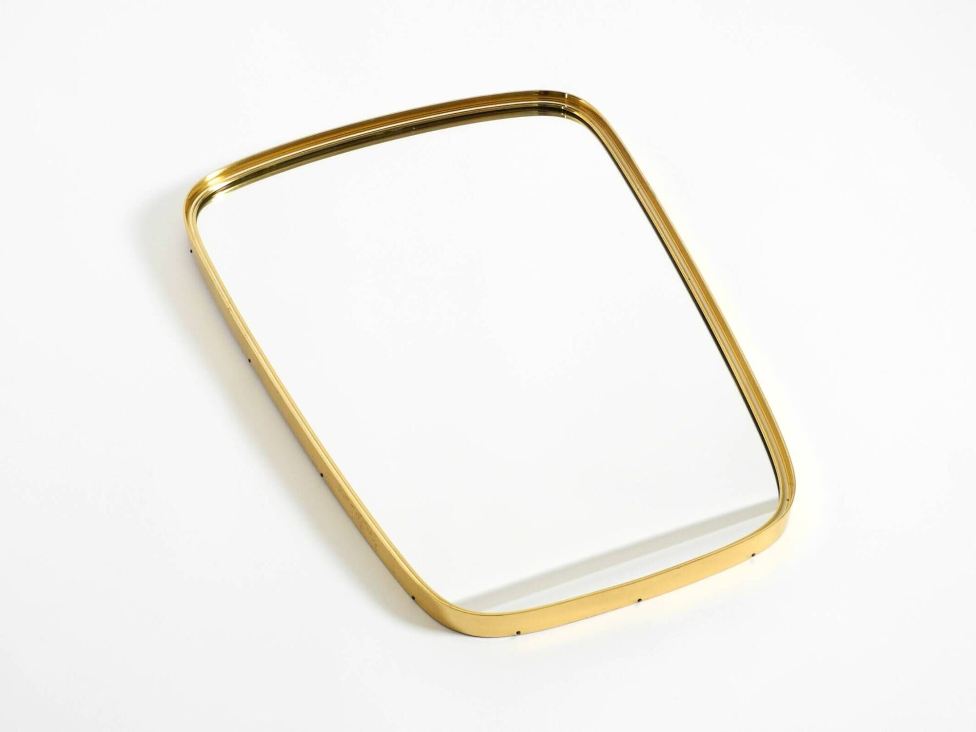 A pair of rare Mid Century "Münchener Zierspiegel" brass wall mirrors