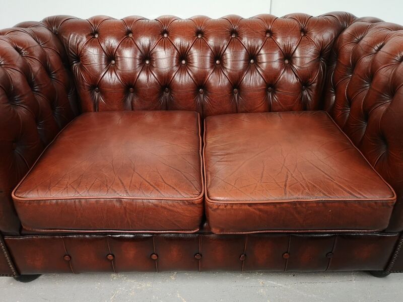 Two-seater brown leather chesterfield sofa