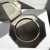 Many octagonal presentation plates in silver-plated metal.