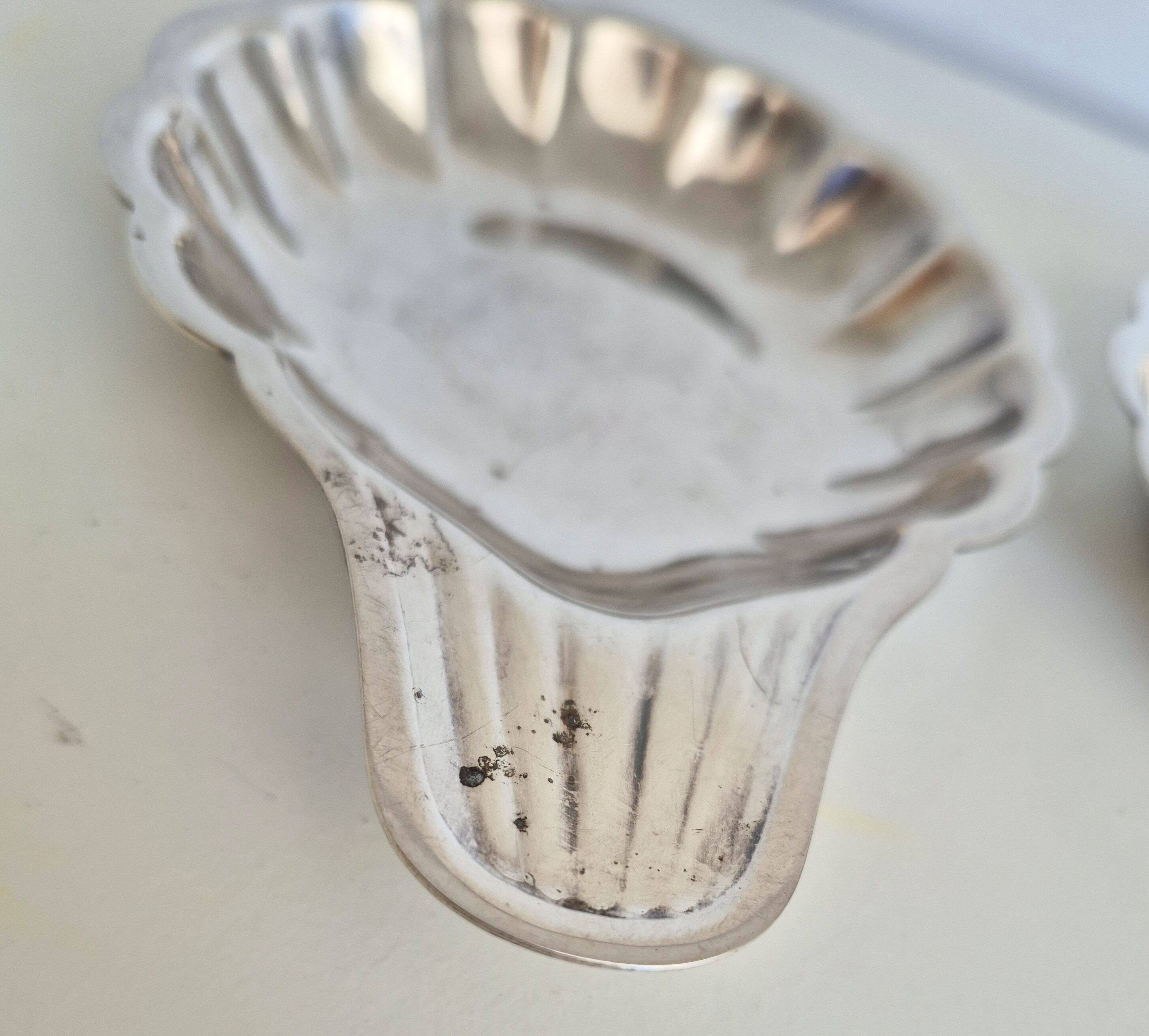 Silver-plated shell-shaped butter dishes, in the shape of a scallop shell.