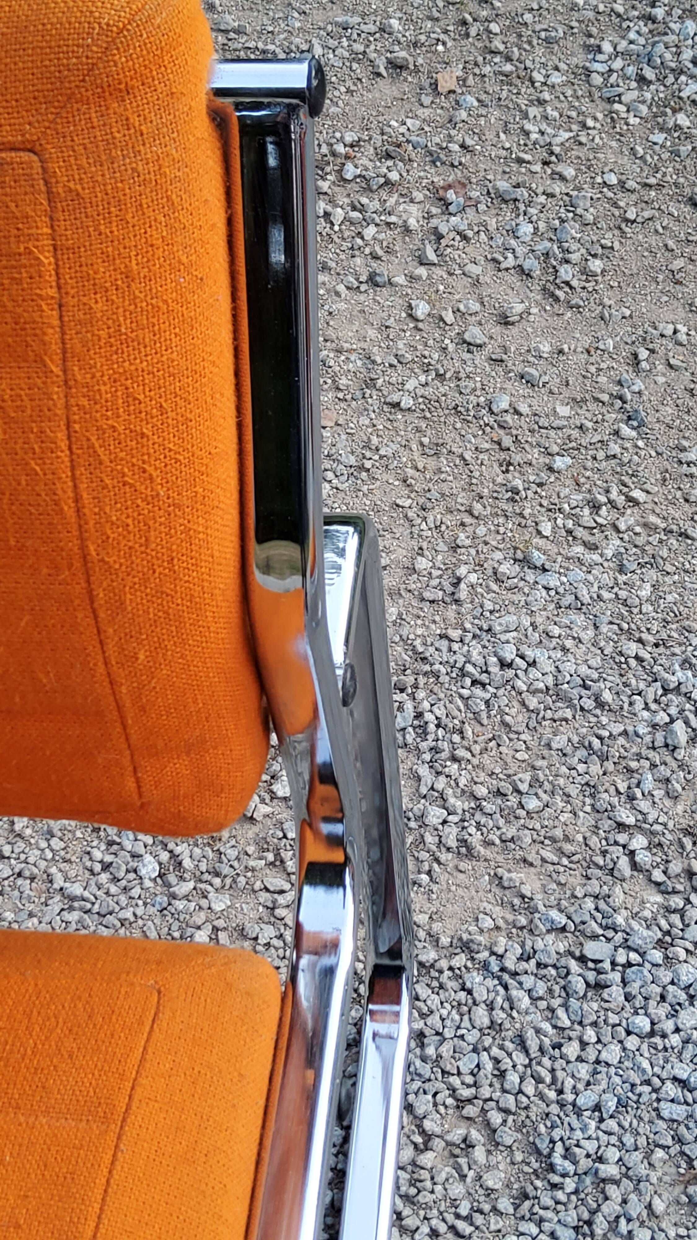 Pair of designer armchairs in orange fabrics and chrome tubes from the 70s
