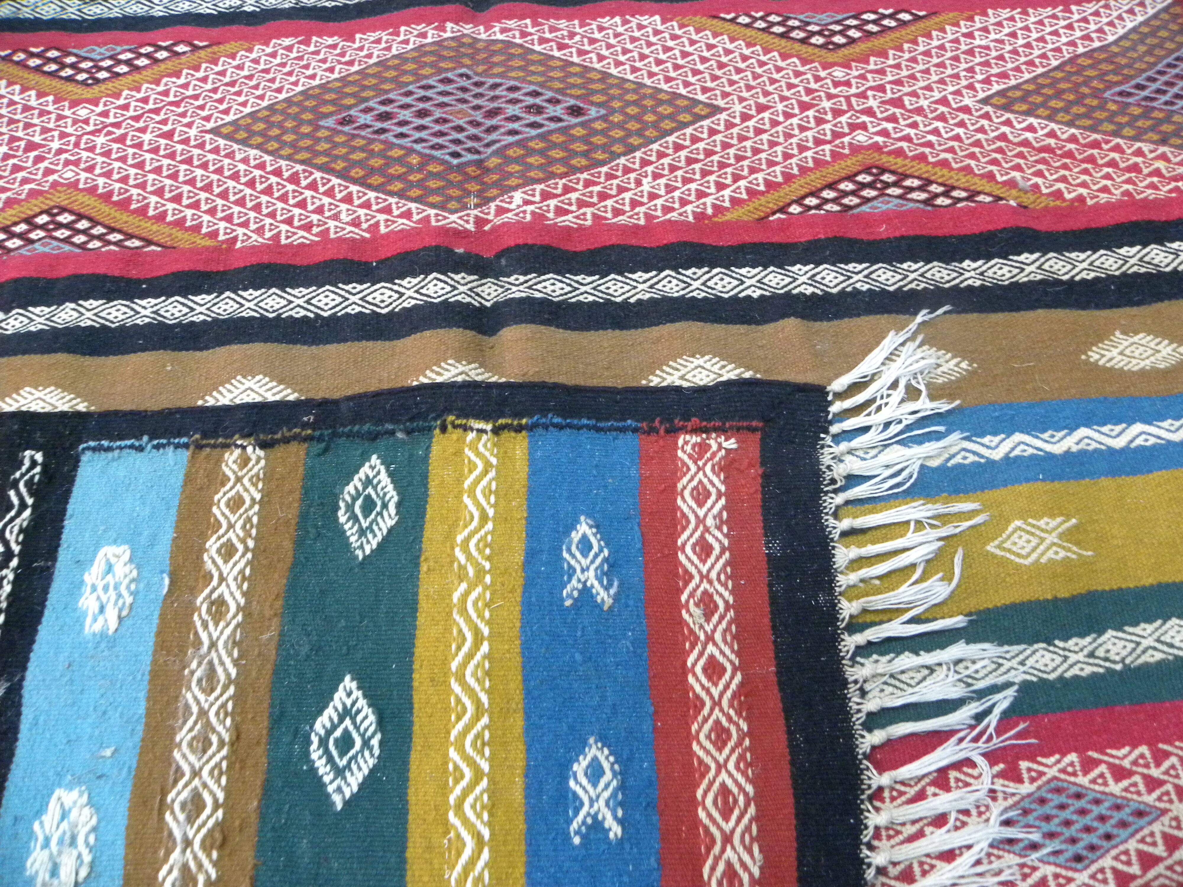 Traditional Berber tribal kilim rug with multicoloured geometric patterns.