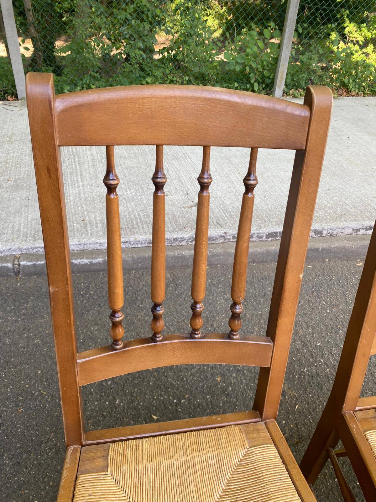 Solid wood chair with a straw seat and carved bar backrest.