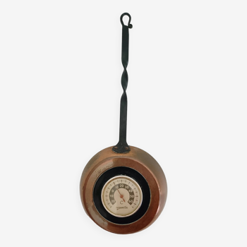 Wall thermometer on copper stove with cast iron handle