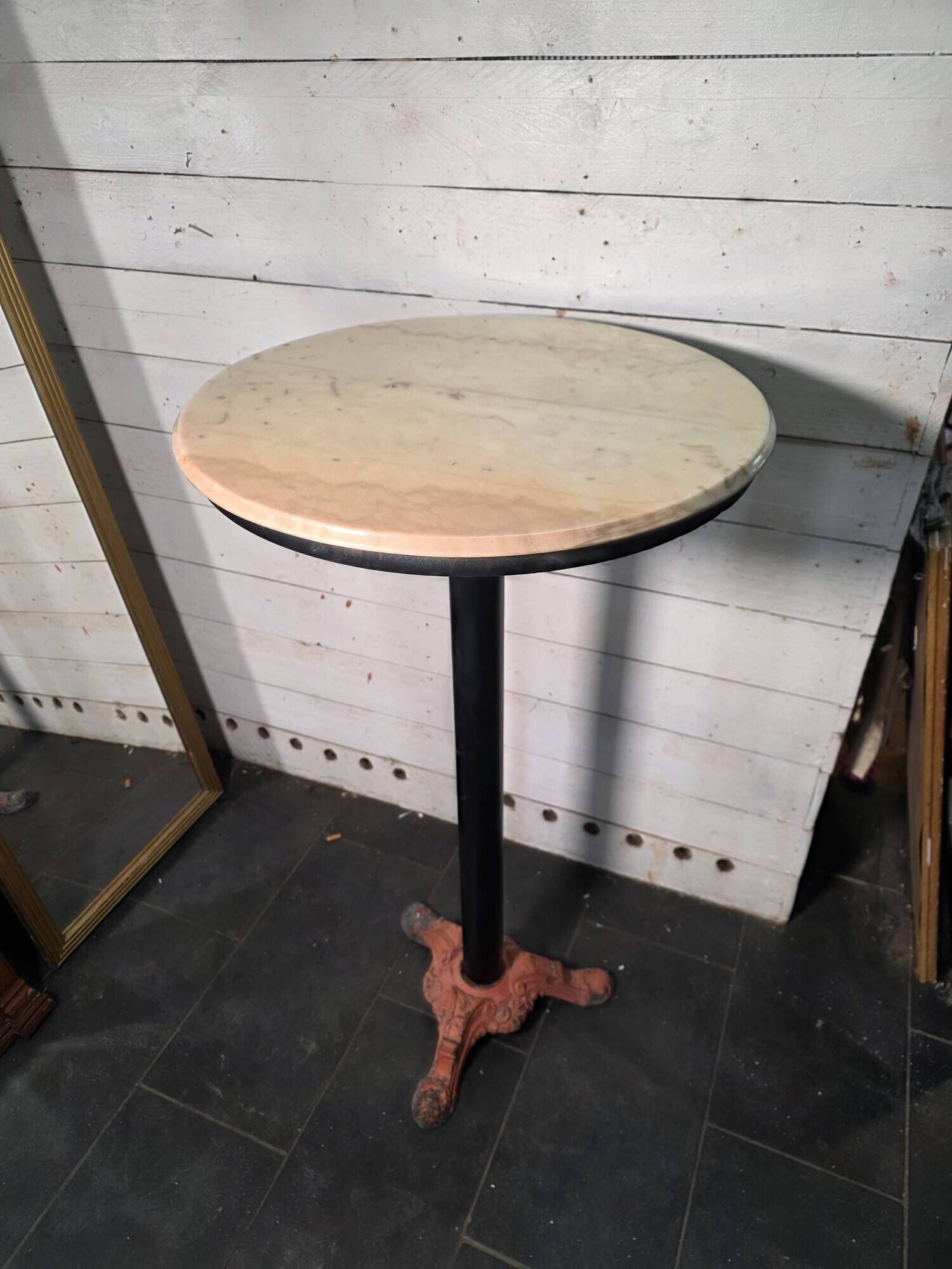 Bistro standing table with marble top and cast iron base.