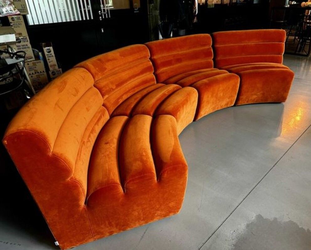 Burnt orange modular sofa for four with a futuristic design.