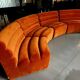 Burnt orange modular sofa for four with a futuristic design.