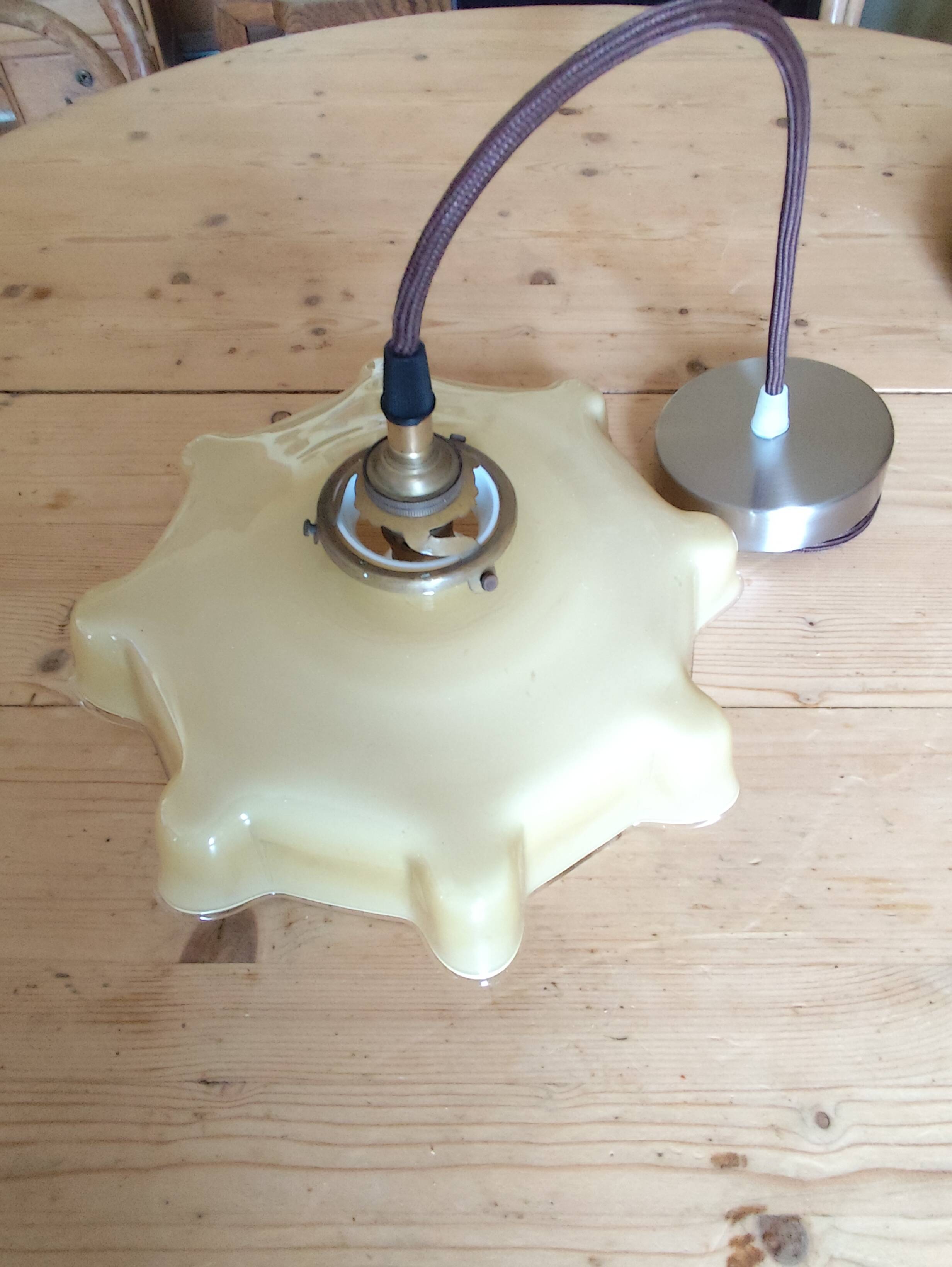 Electrified suspension with a frosted opaque glass disc shade.