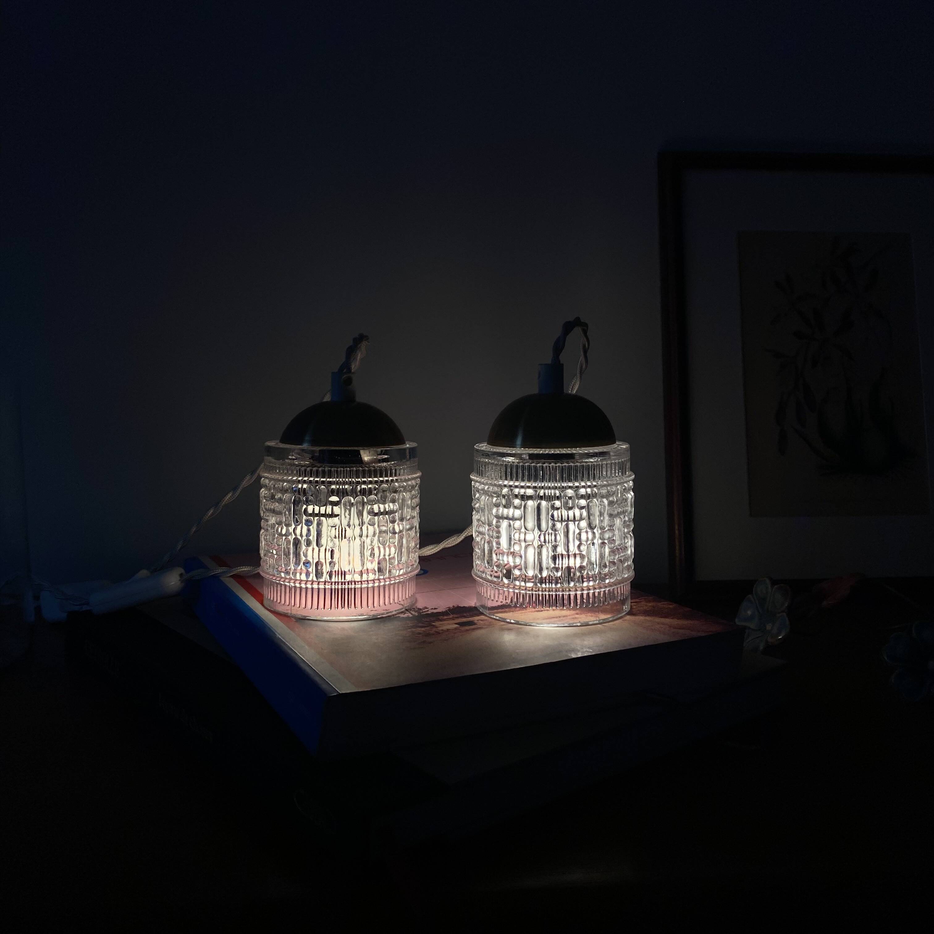 Pair of small portable tulip lamps in transparent glass.