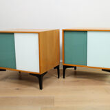 A pair of vintage mid-century bedside tables with glass sliding doors