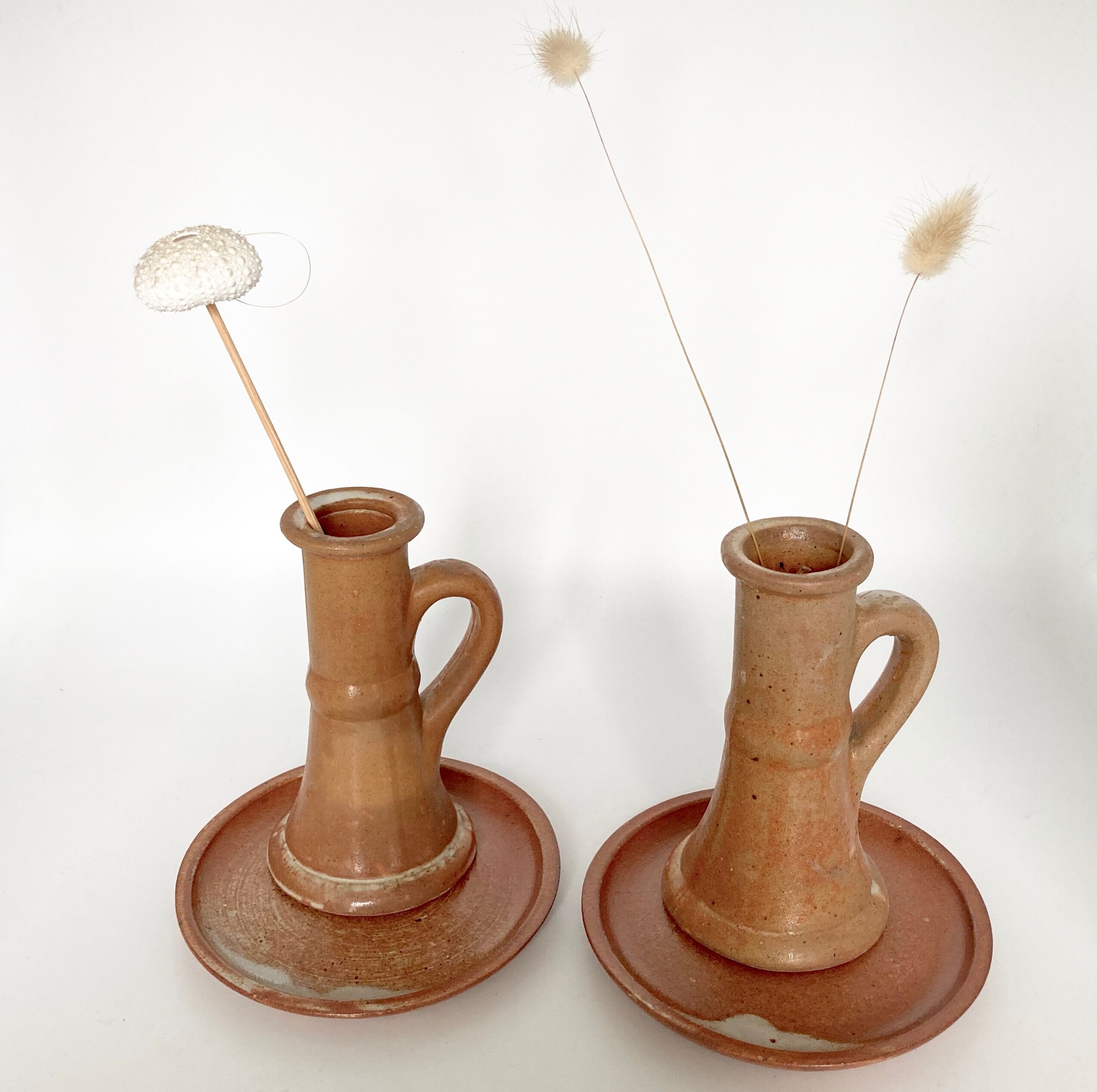 Pair of candlesticks and two sandstone cups