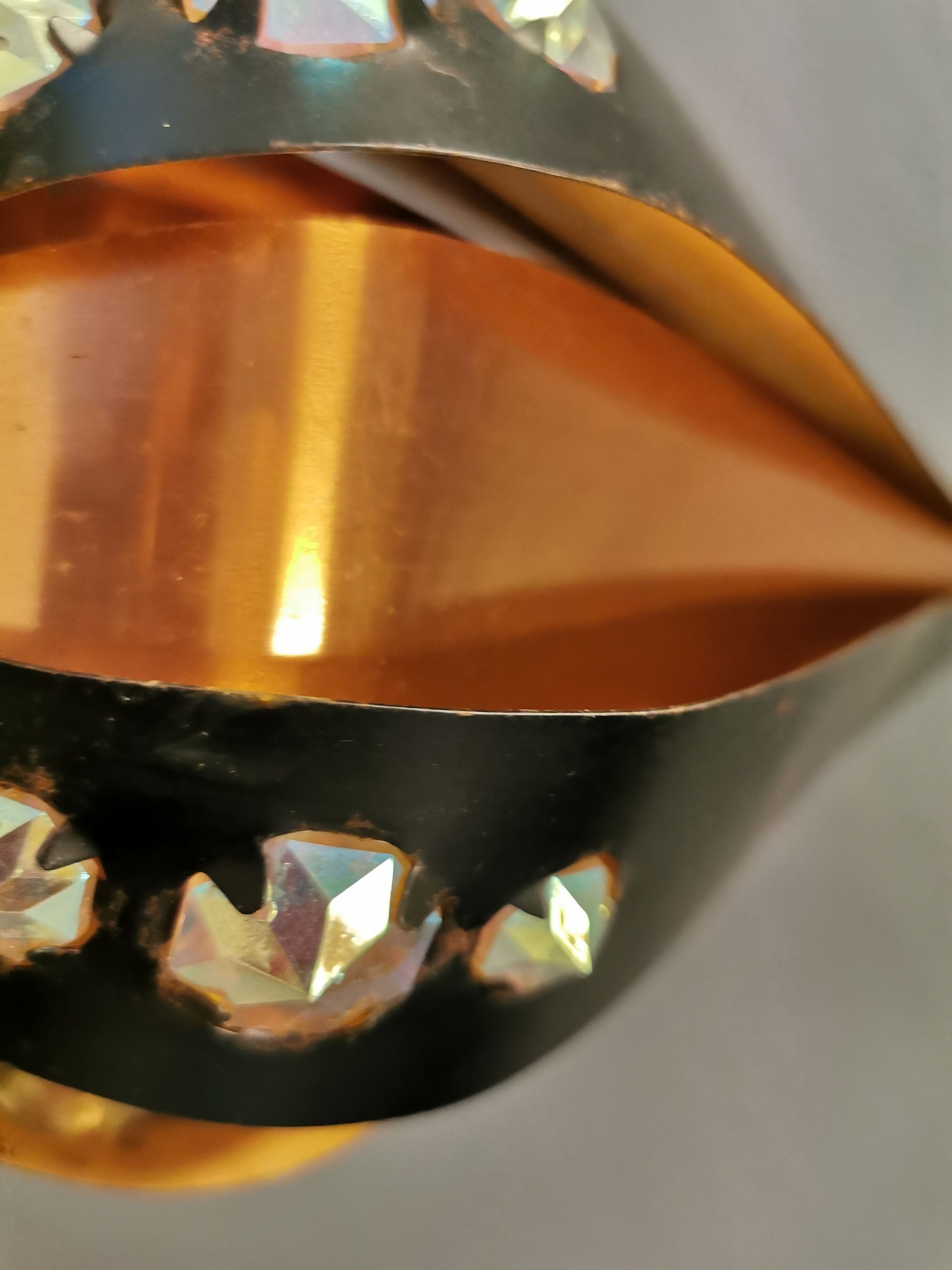 Hanging lamp in thin metal pieces, copper colored and black with prisms.