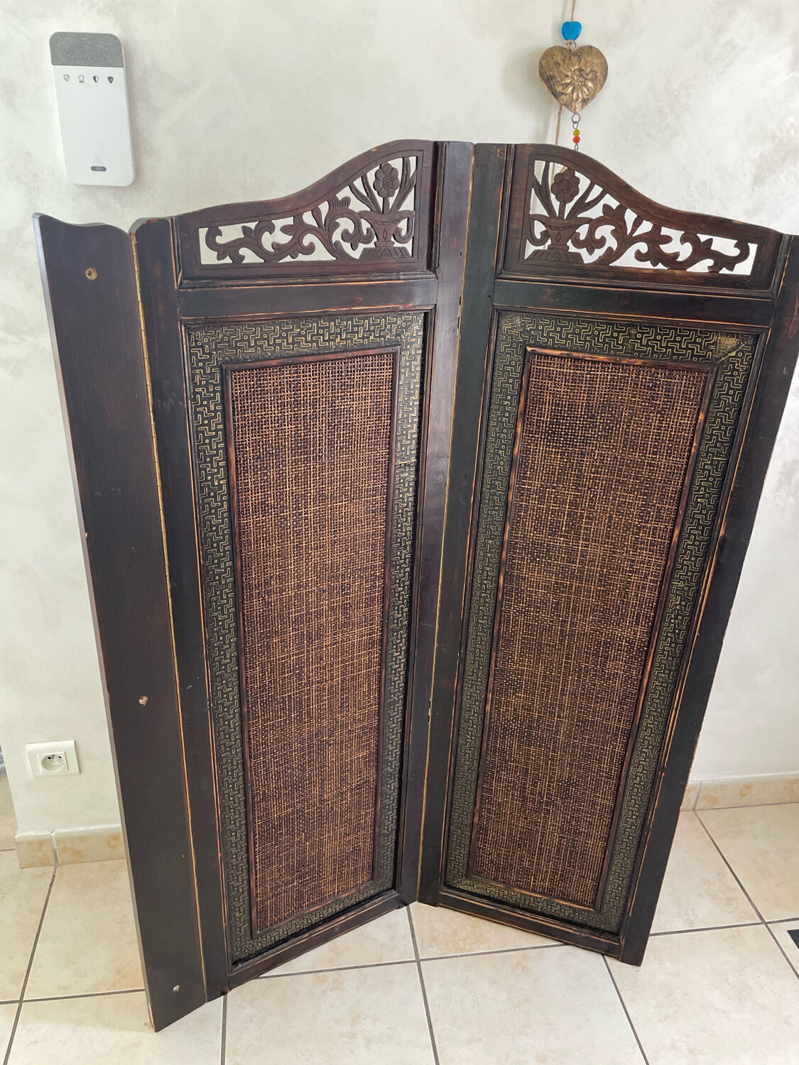 Antique wooden wall panel with carving and cane in an Asian style.