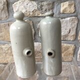 Lot of two old bottles of beige enamelled sandstone bottles