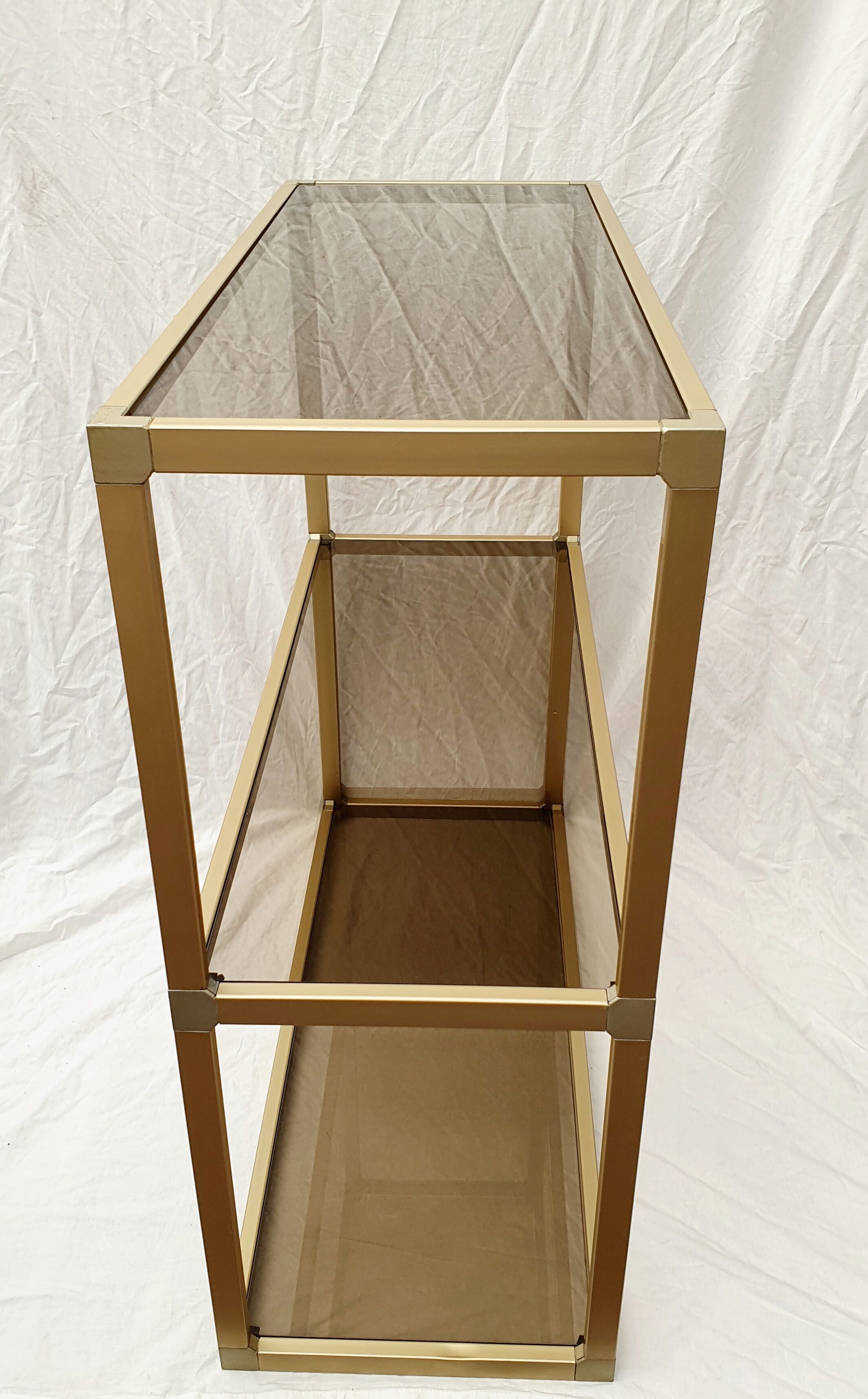 Golden metal shelf and smoked glass