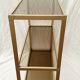 Golden metal shelf and smoked glass