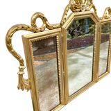 Triptych-shaped mirror in gilded wood and carved with a frieze