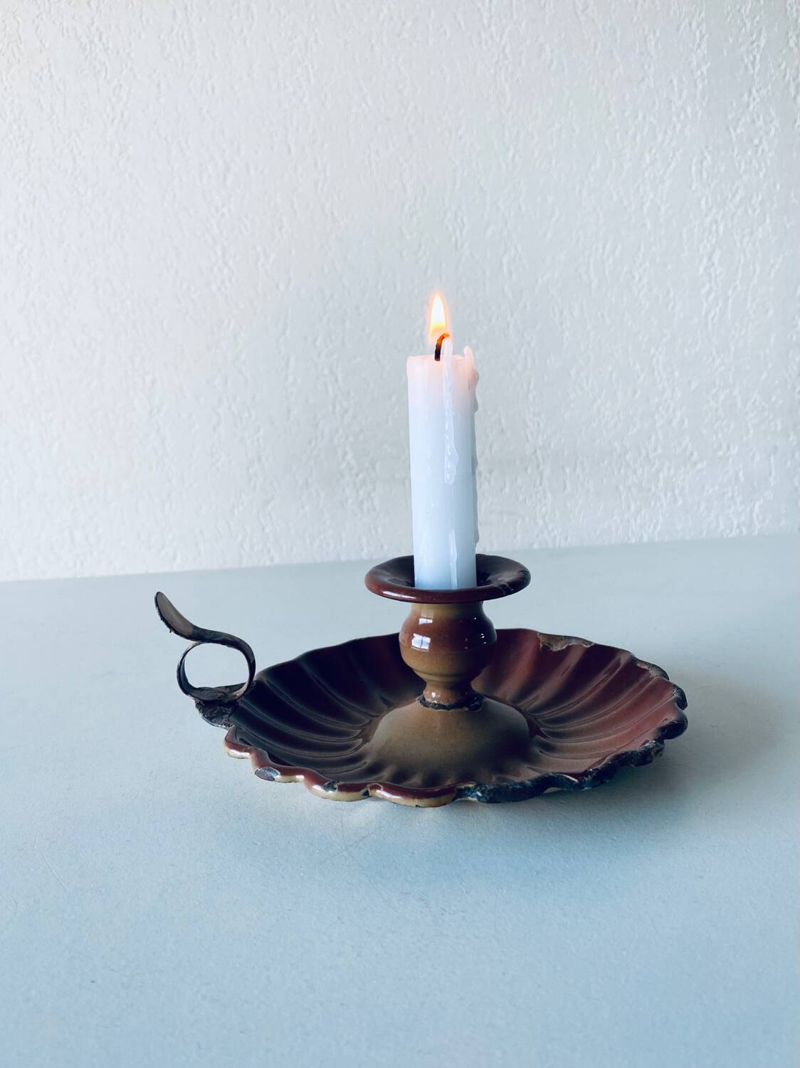 Old candle holder in brown enameled metal