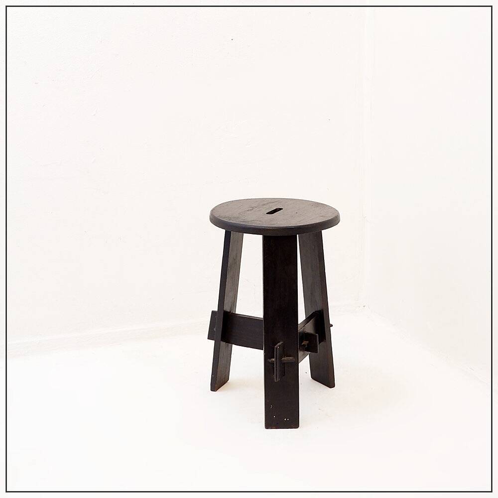 Vintage black-stained wooden tripod stool with mortise joints.