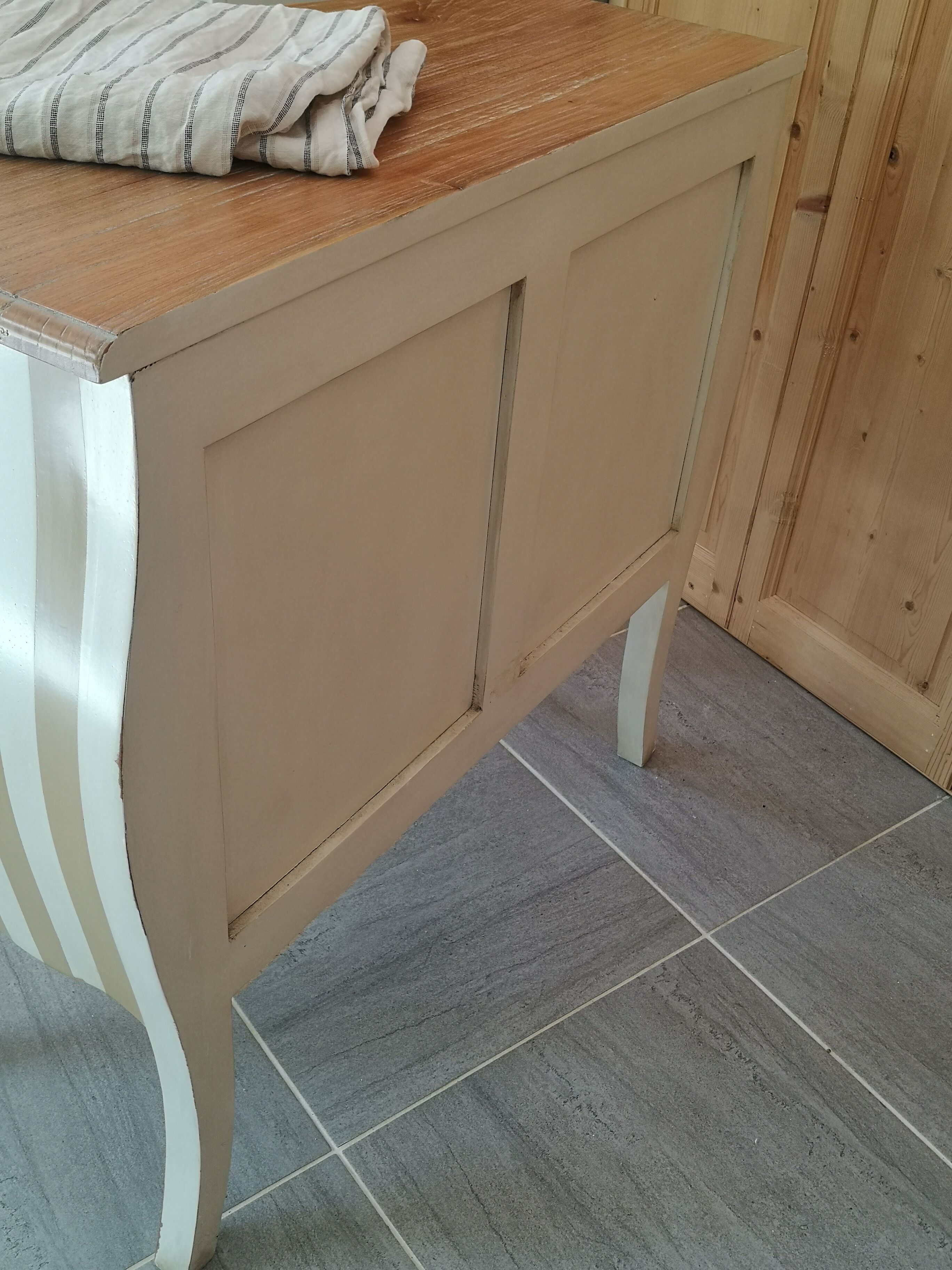 Curved commode with beige and white stripes.