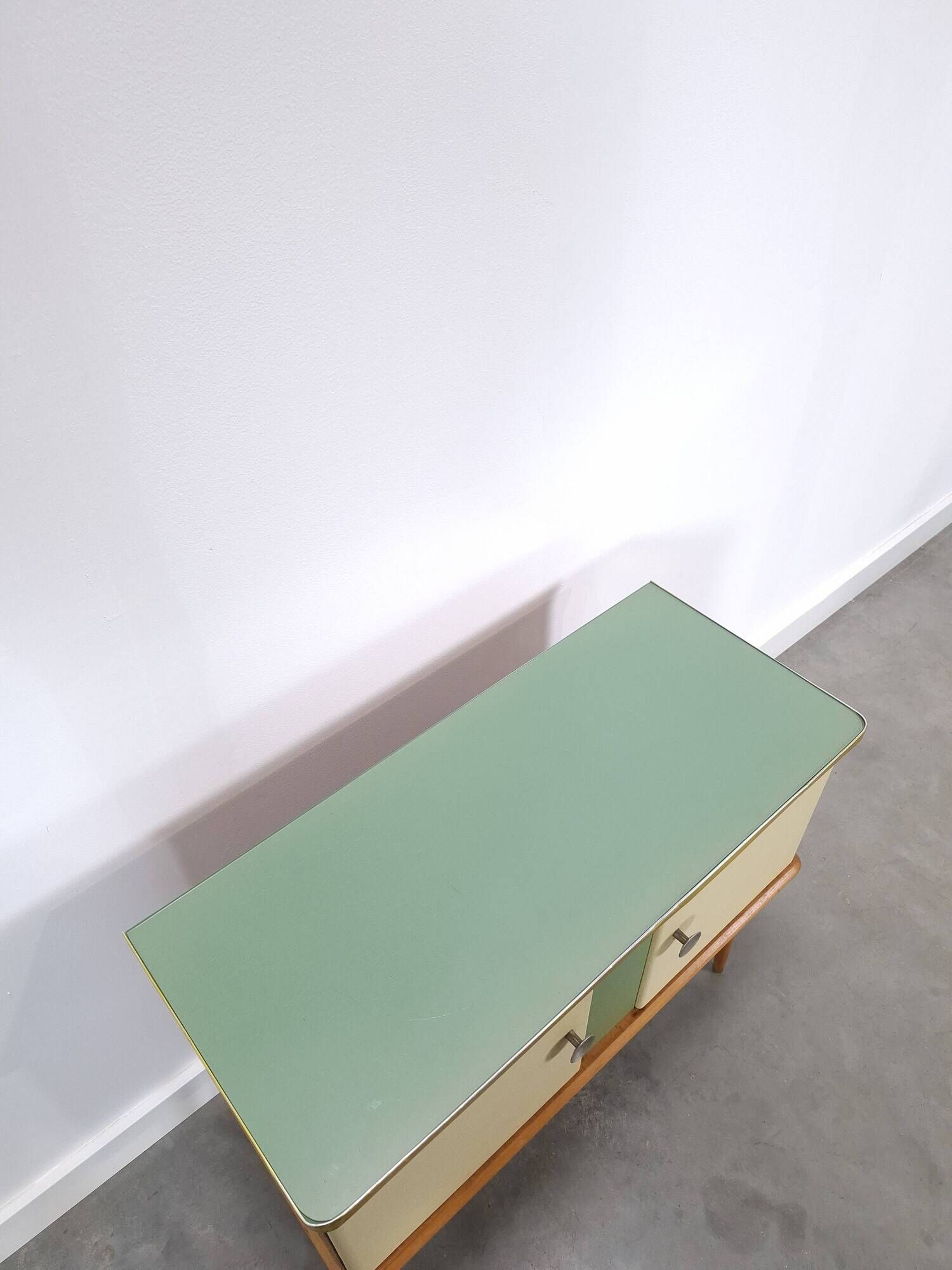 Vintage green DDR cabinet, model Libelle with glass top, slanted legs.