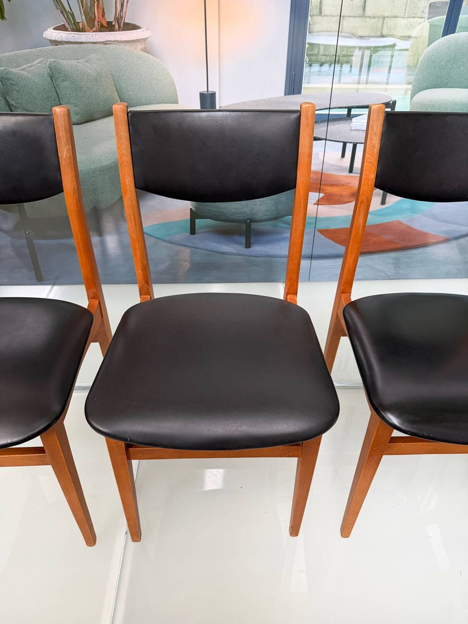 4 Scandinavian chairs in teak and black faux leather.