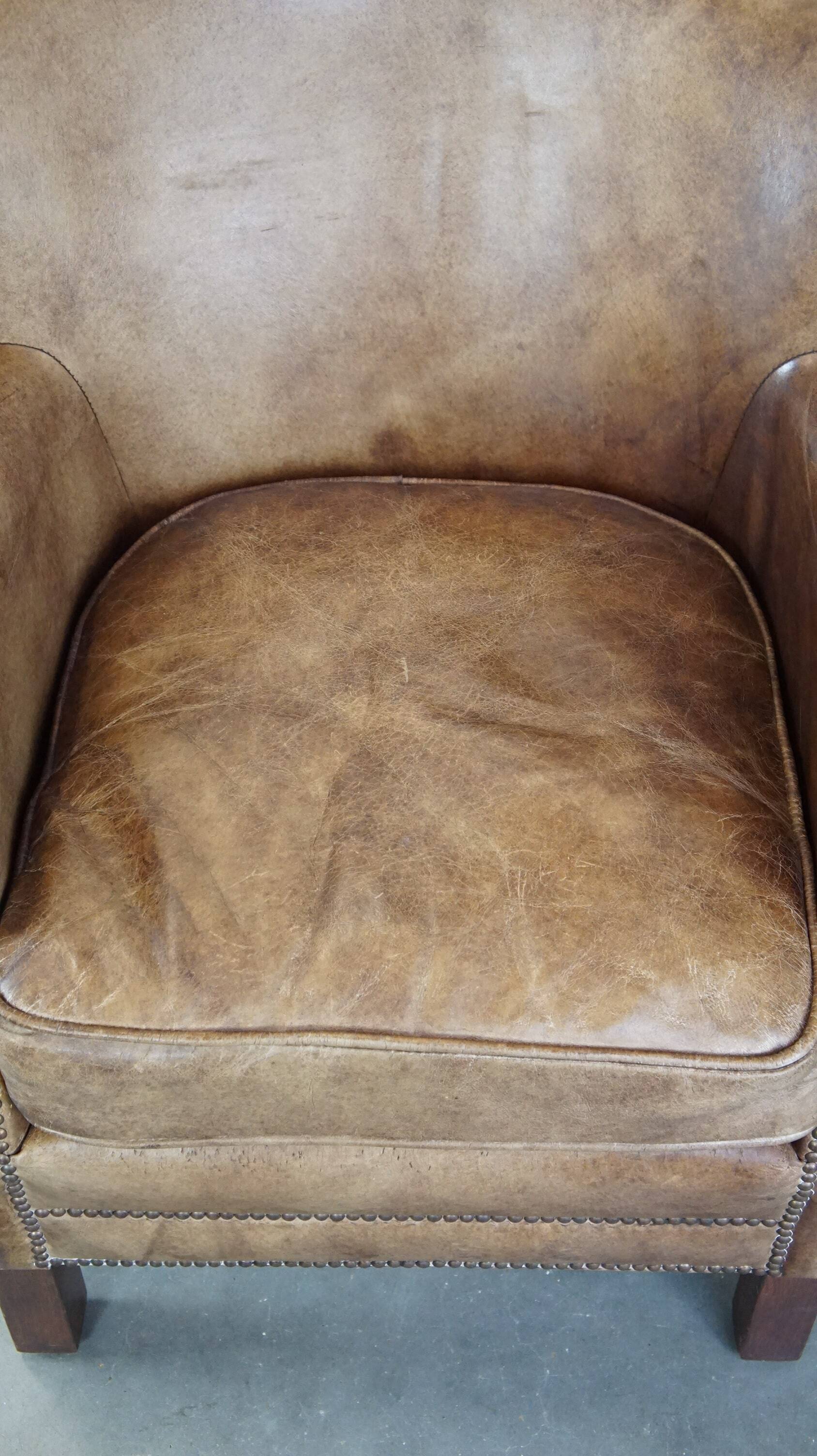 Subtle leather armchair with a reversible kilim seat cushion