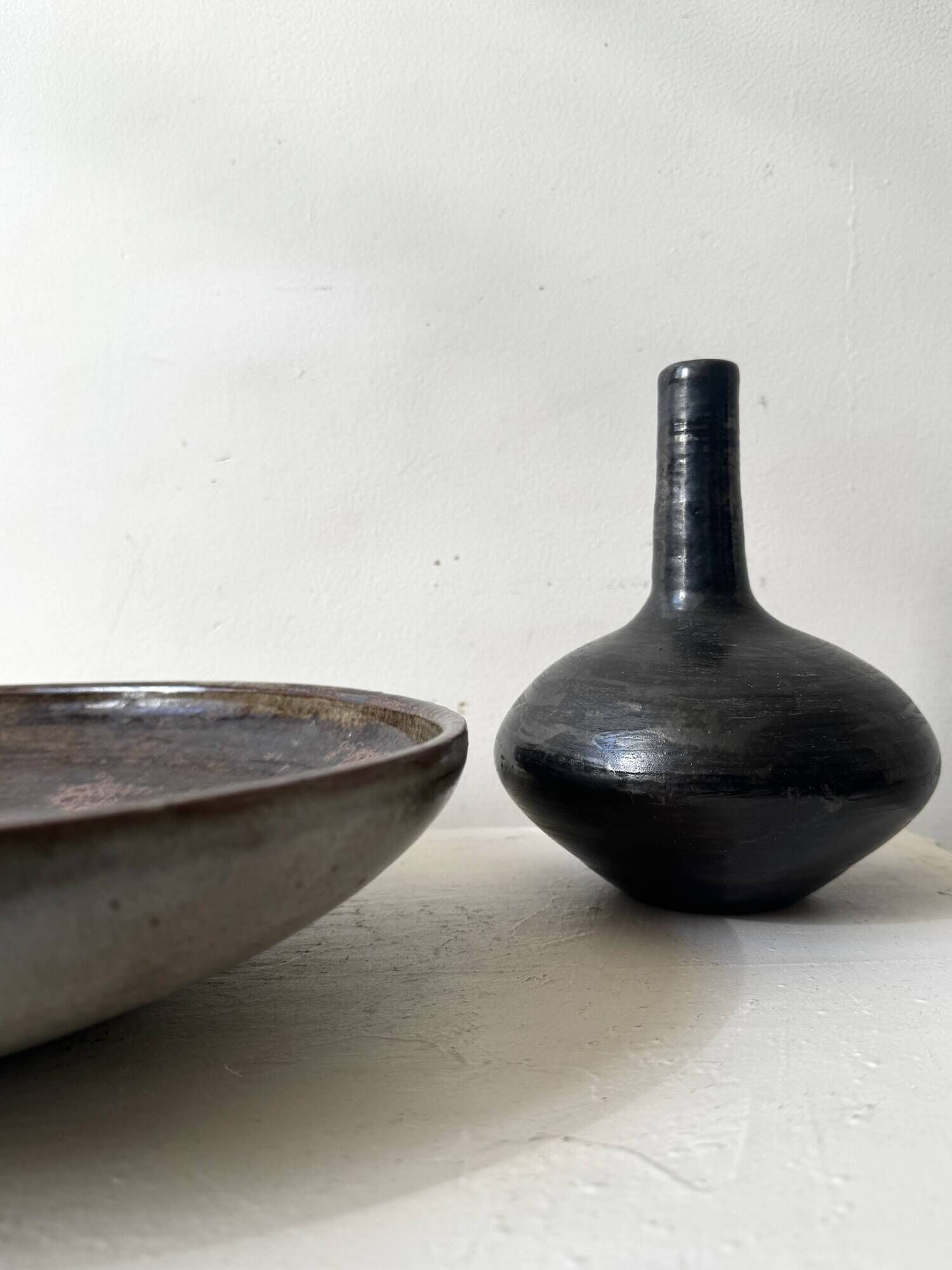 Glazed black ceramic vase with a single stem, signed, circa 1950.