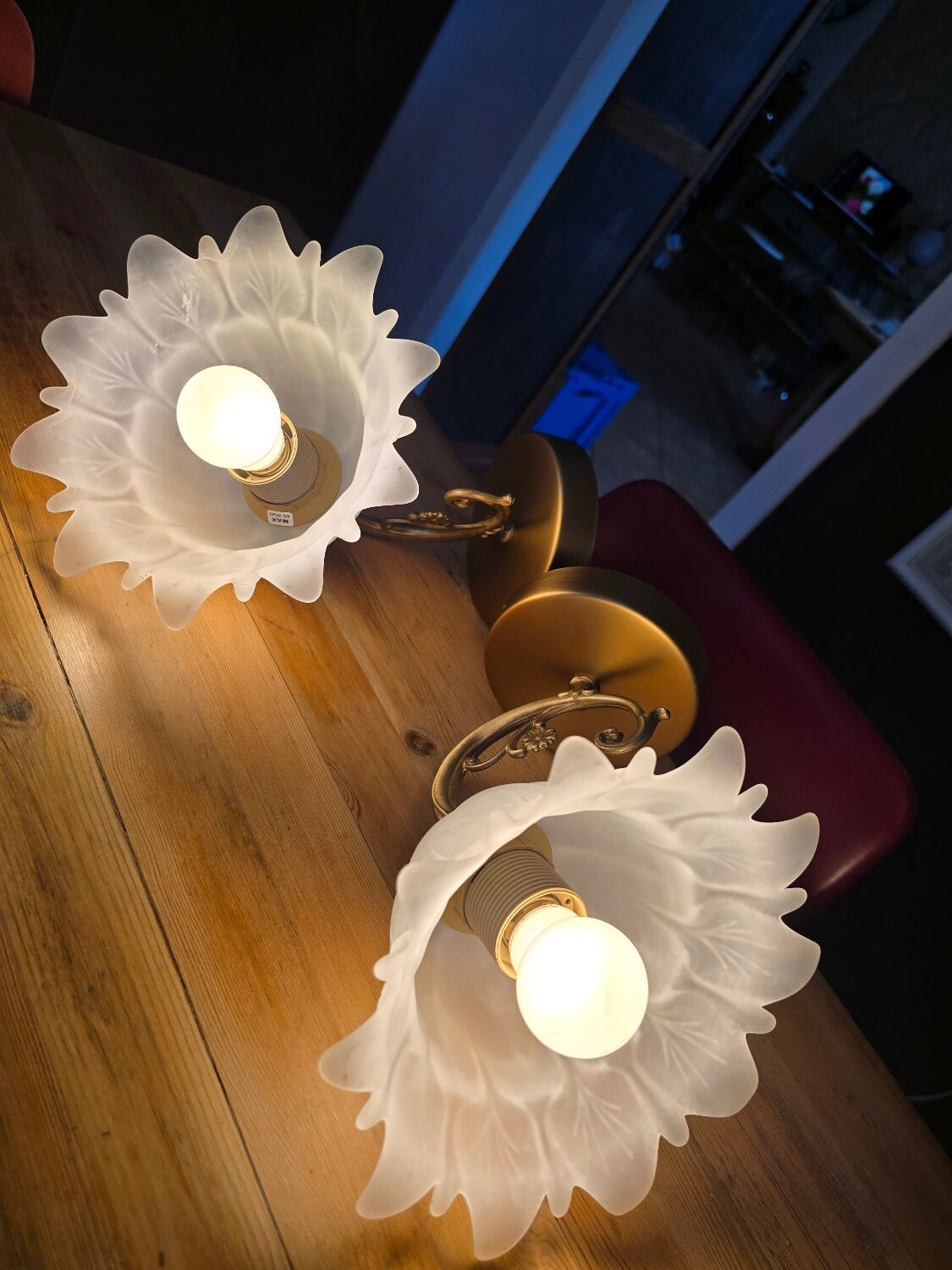 Frosted glass tulip wall sconces with brass arms.