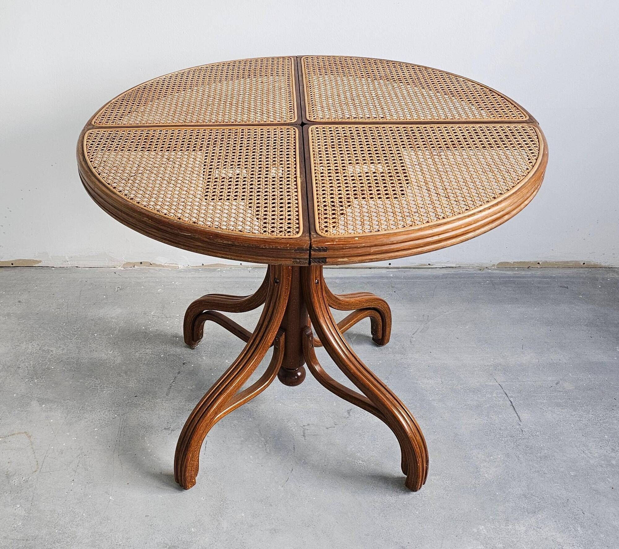 Round dining table in curved wood with a rattan top by Mundus, 1960s.