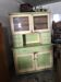Vintage wooden kitchen cupboard painted green and beige, with glass doors - 1930s