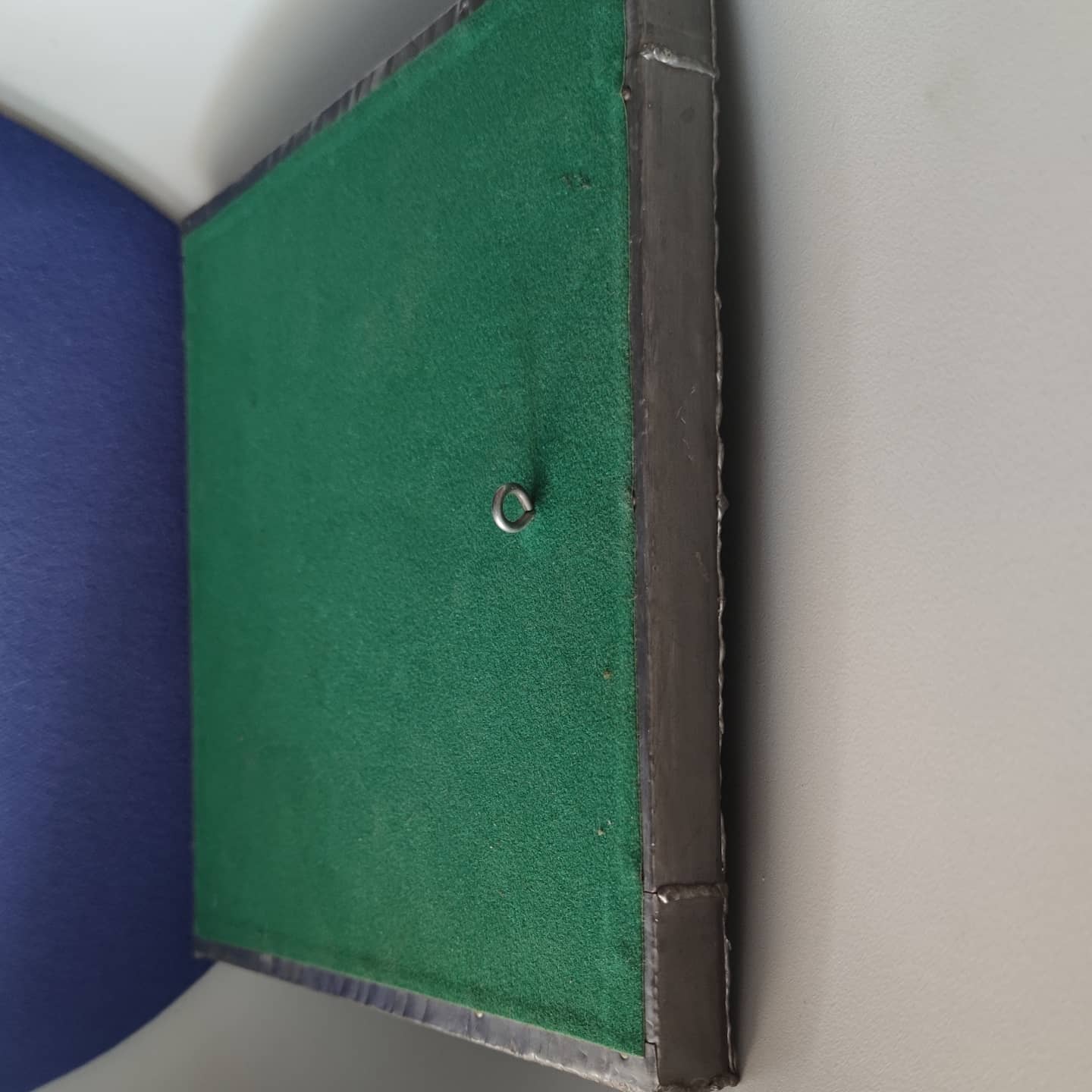 Pewter mirror on a brutalist-style wooden stand