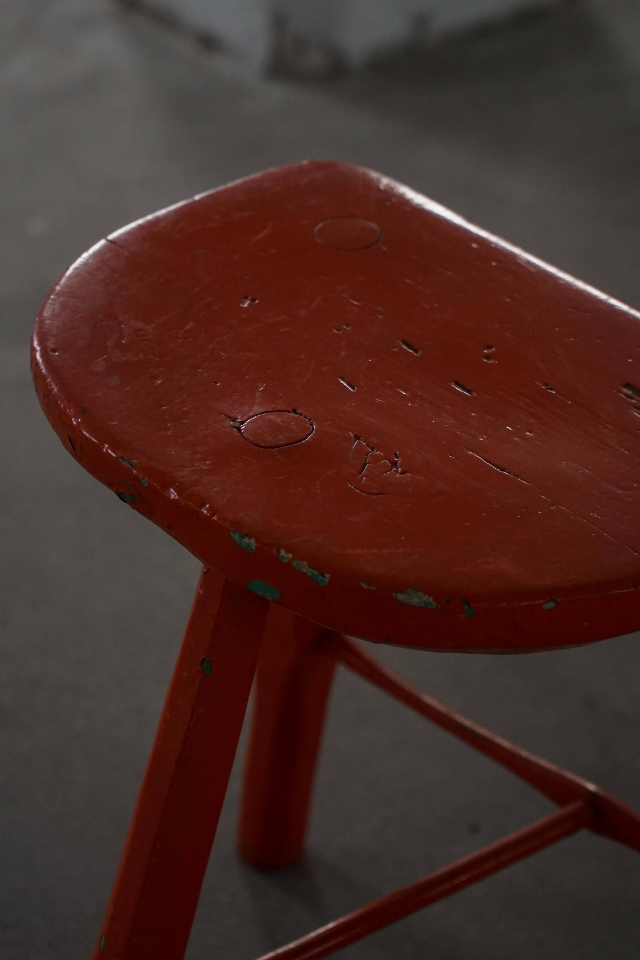 Pair of patinated wooden stools painted red with flared legs, 1950s-1960s.