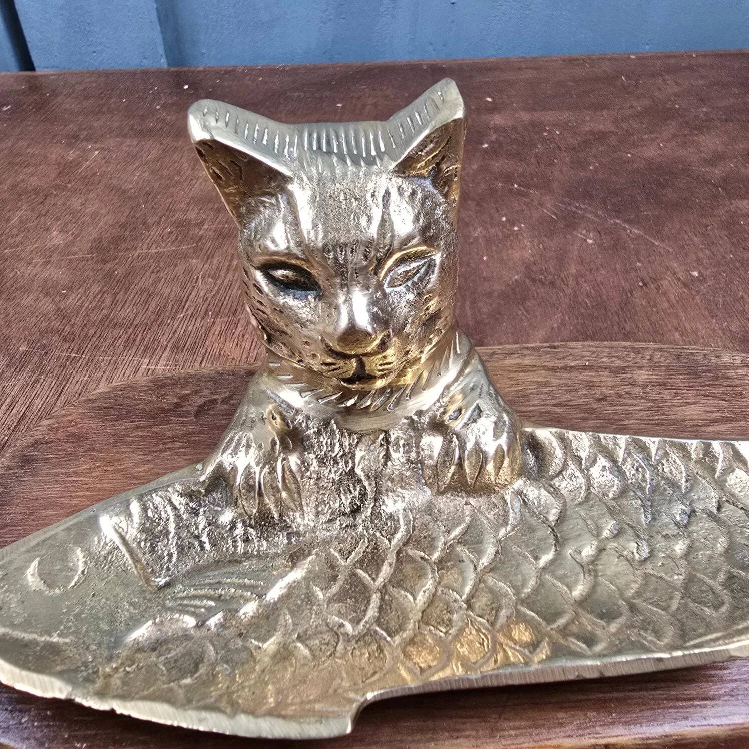Vintage cat fish catchall in brass on a solid wood base.