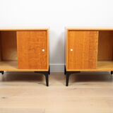 A pair of vintage mid-century bedside tables with oak sliding doors