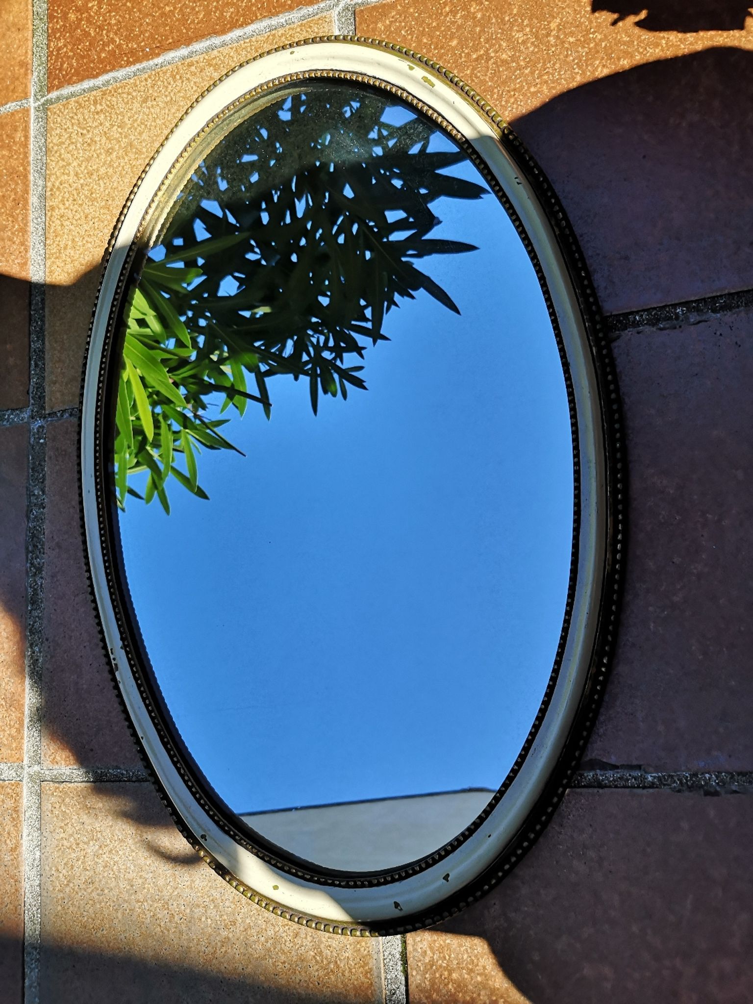 Ancien miroir ovale guilloché doré et peint