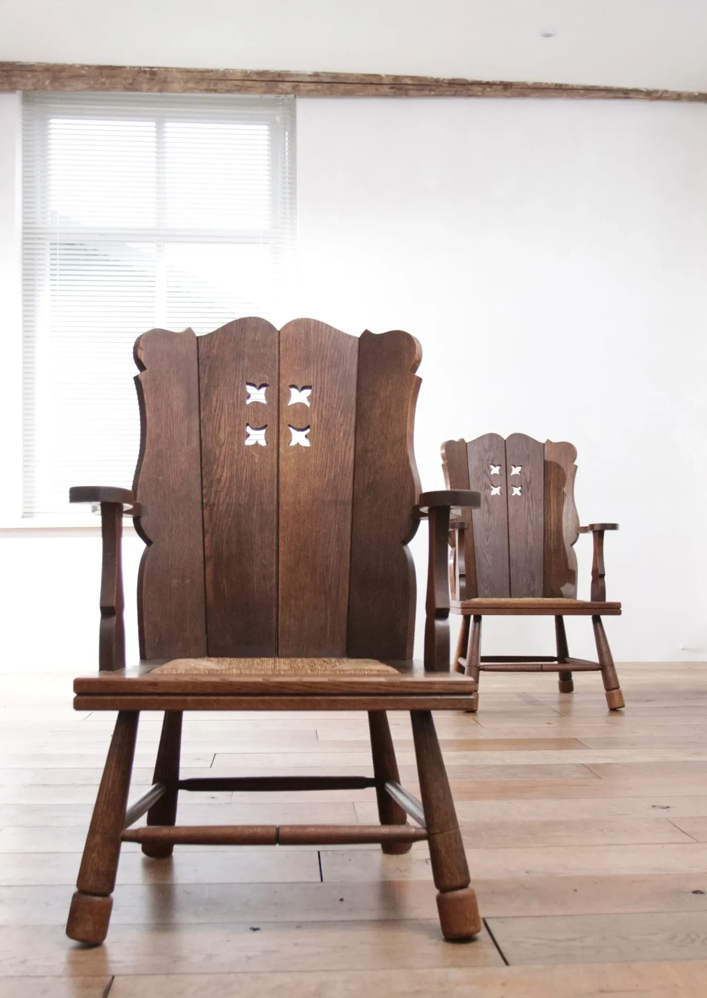 Pair of brutalist oak lounge chairs with rush seats, circa 1935