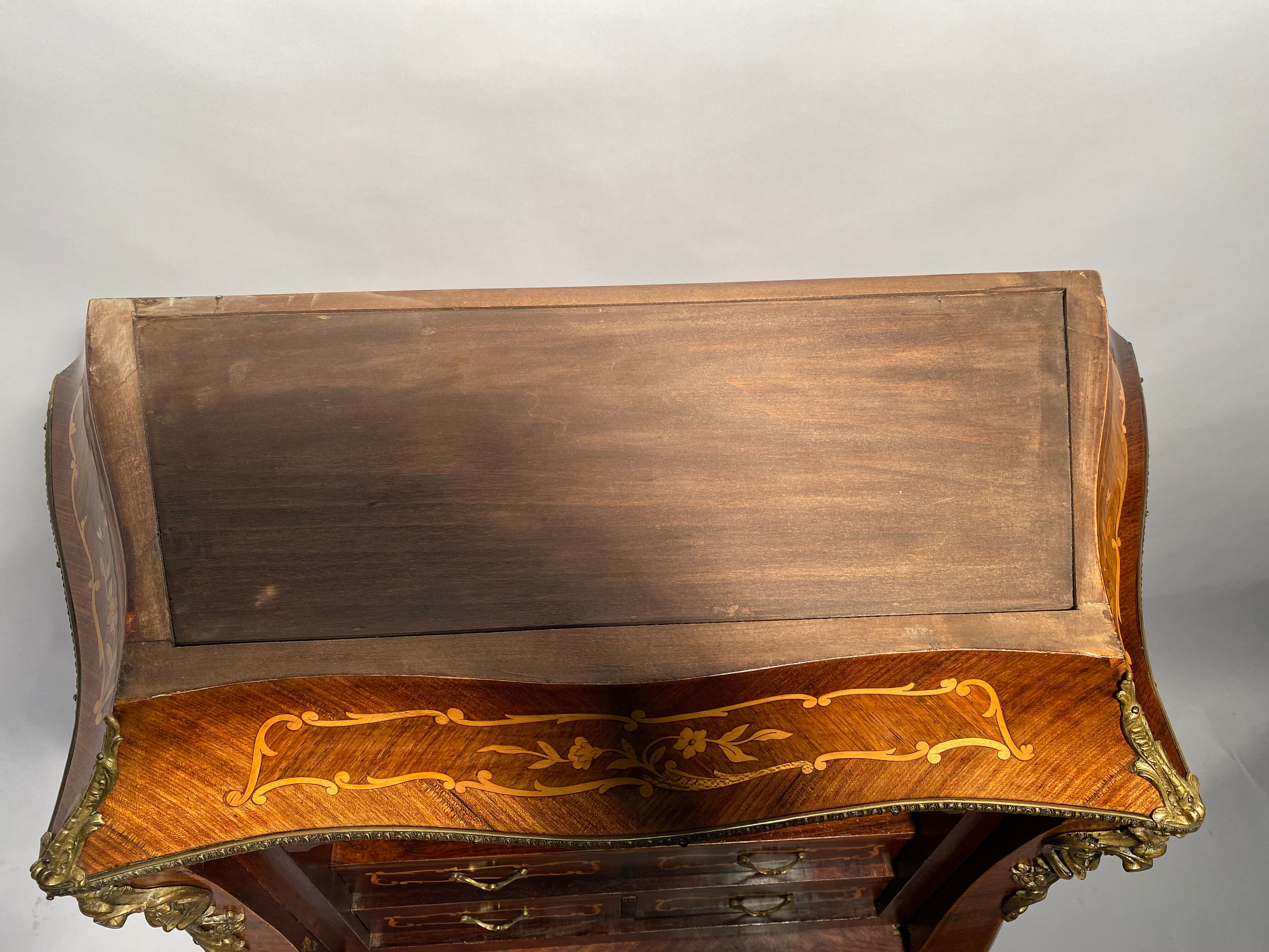 Curved secretary and inlaid with floral branches in Louis XV style