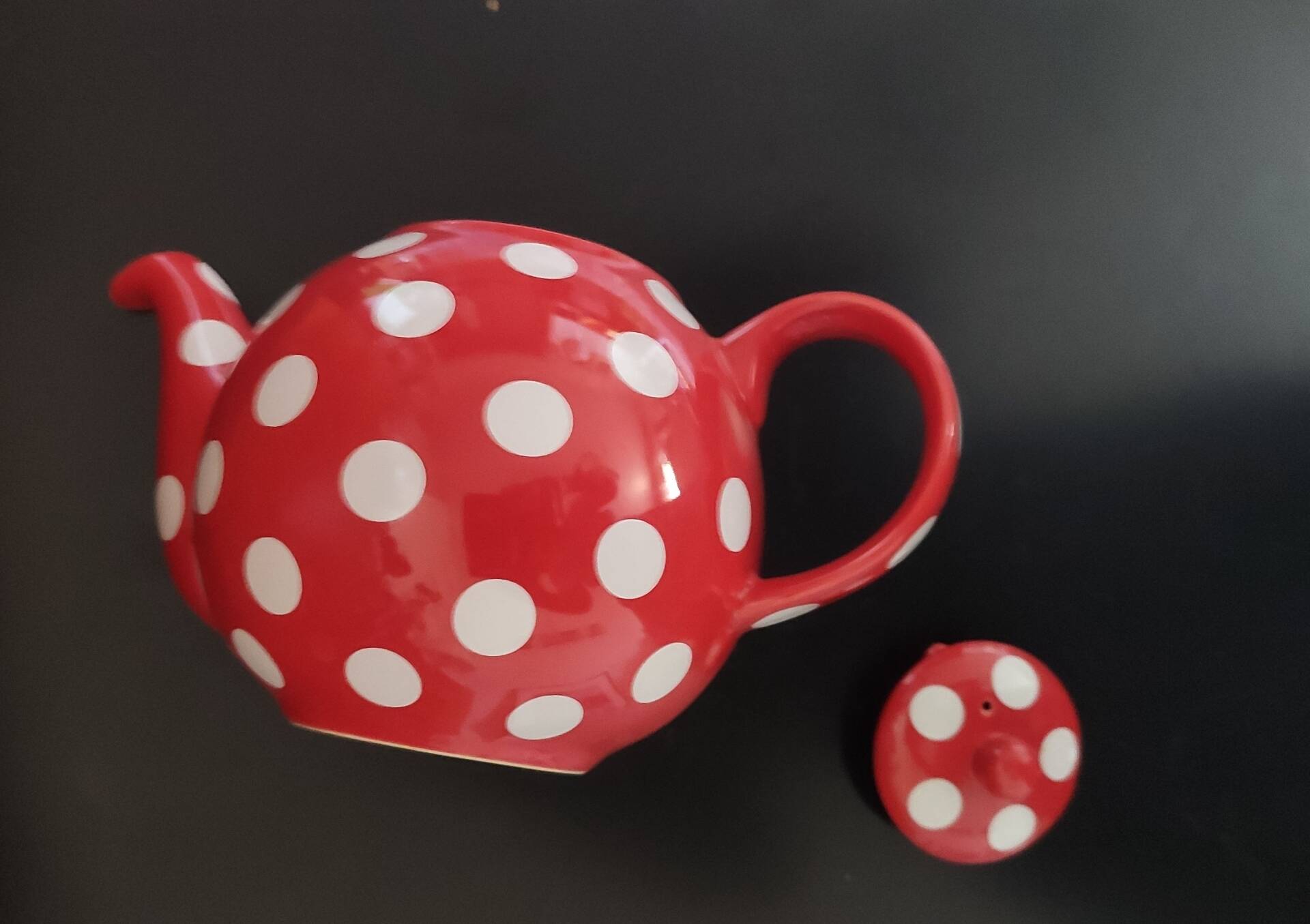 Pretty round English teapot with red polka dots.