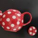 Pretty round English teapot with red polka dots.
