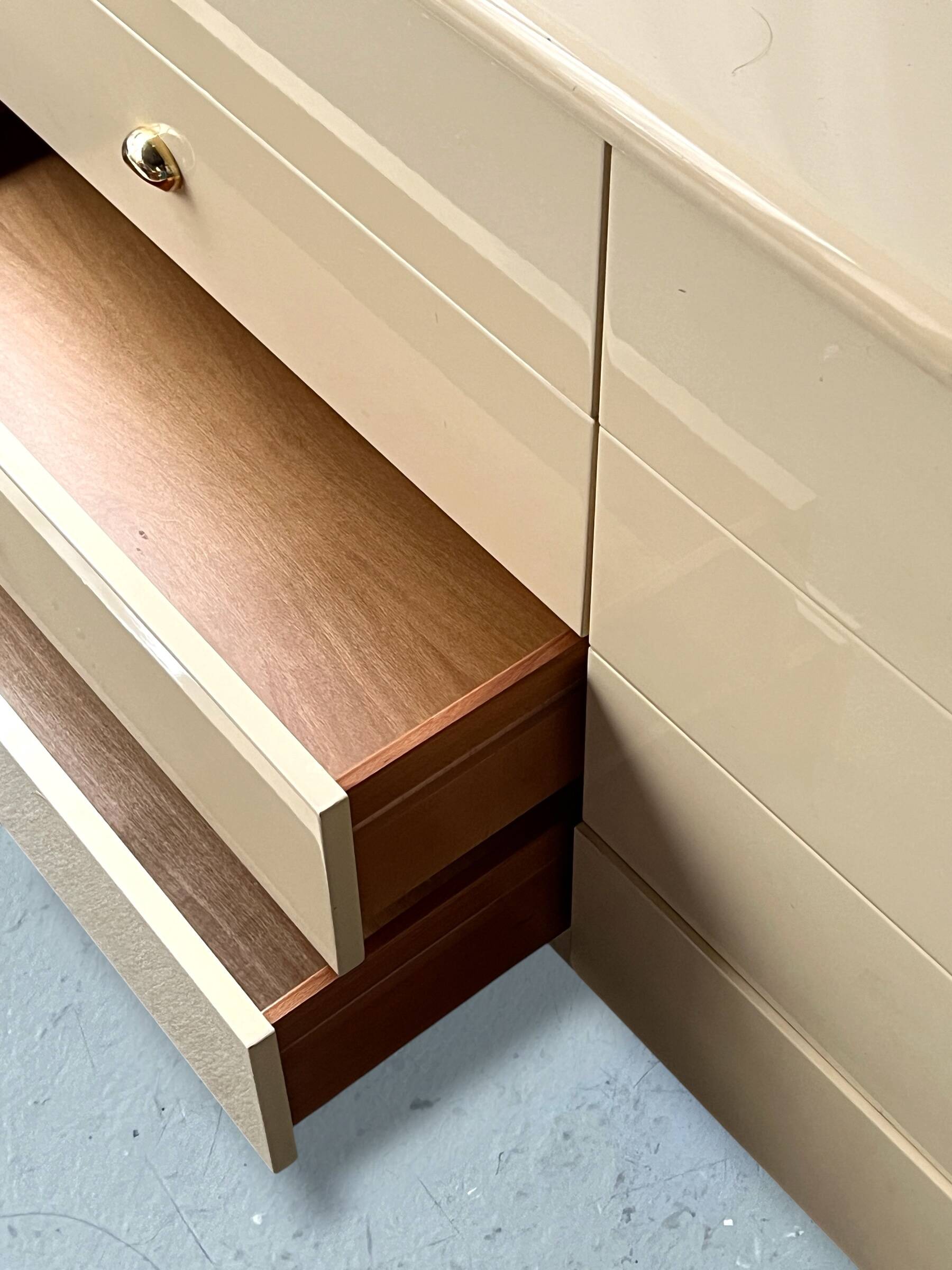 Commode type sideboard with 8 drawers, ivory lacquer and brass details, 1970s design.