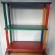 Shelf on legs, library, crayons in 4 colours.