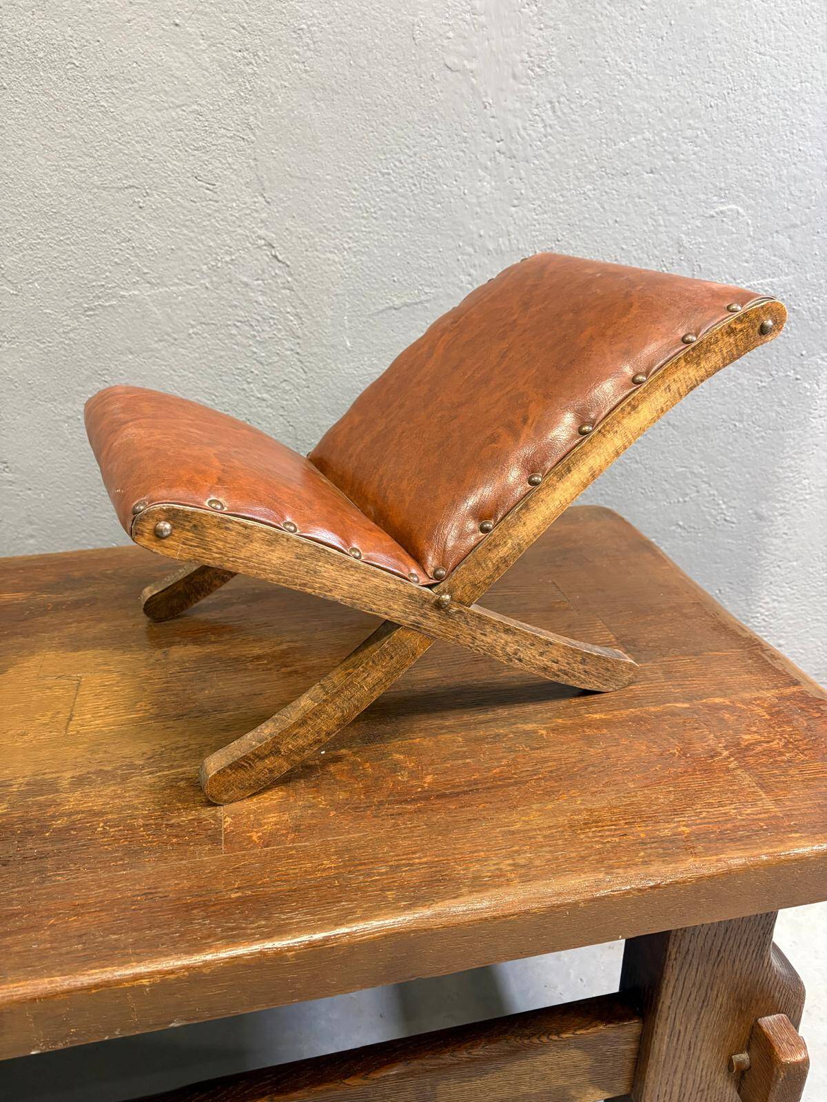 Old retro footstool, mid-century wooden leather stool, mid 20th century, European