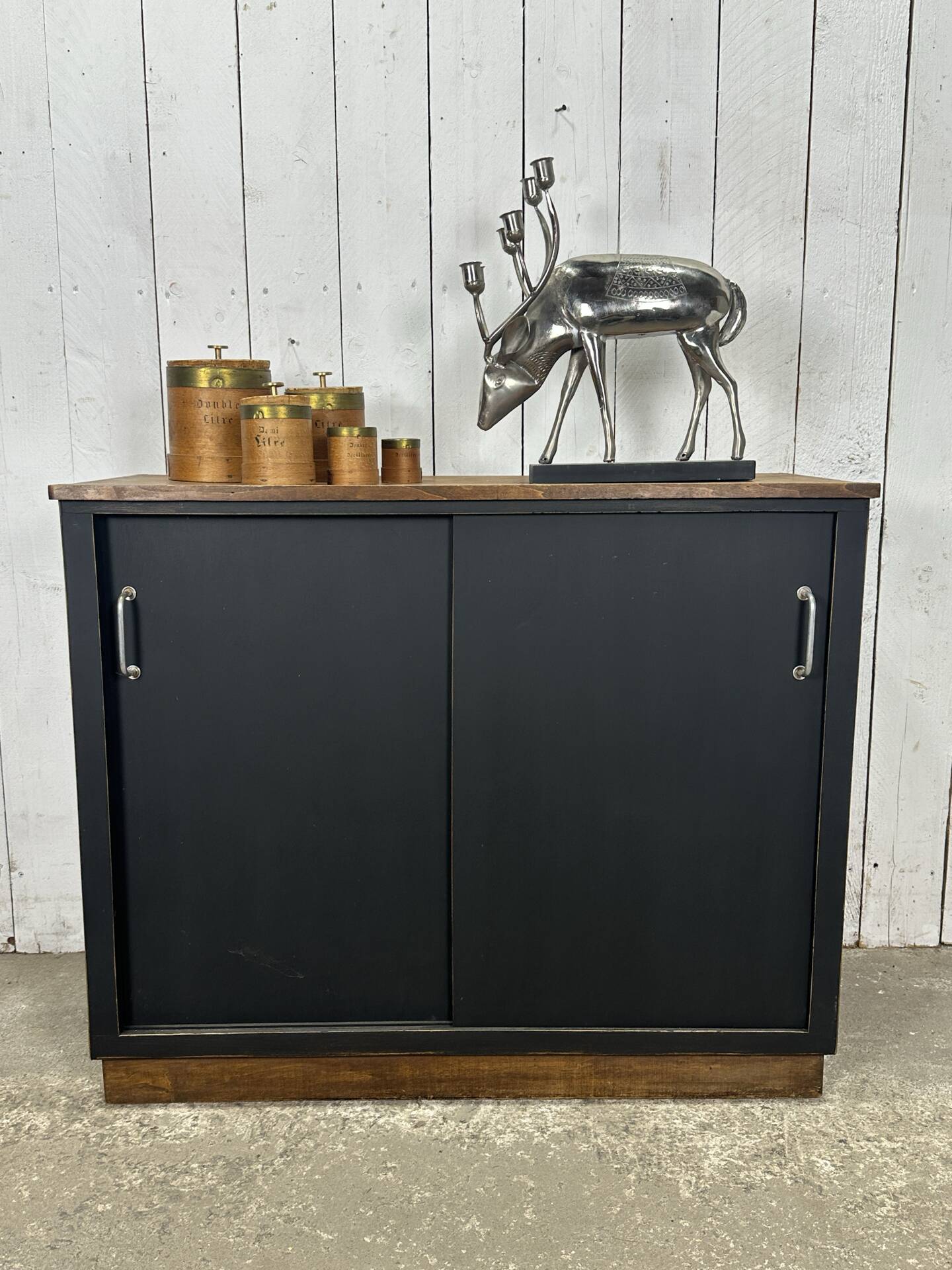 Small vintage black buffet with sliding doors.