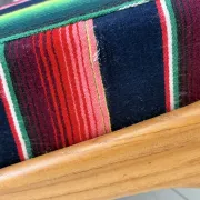 Scandinavian-style armchair in curved wood and colourful striped fabric.