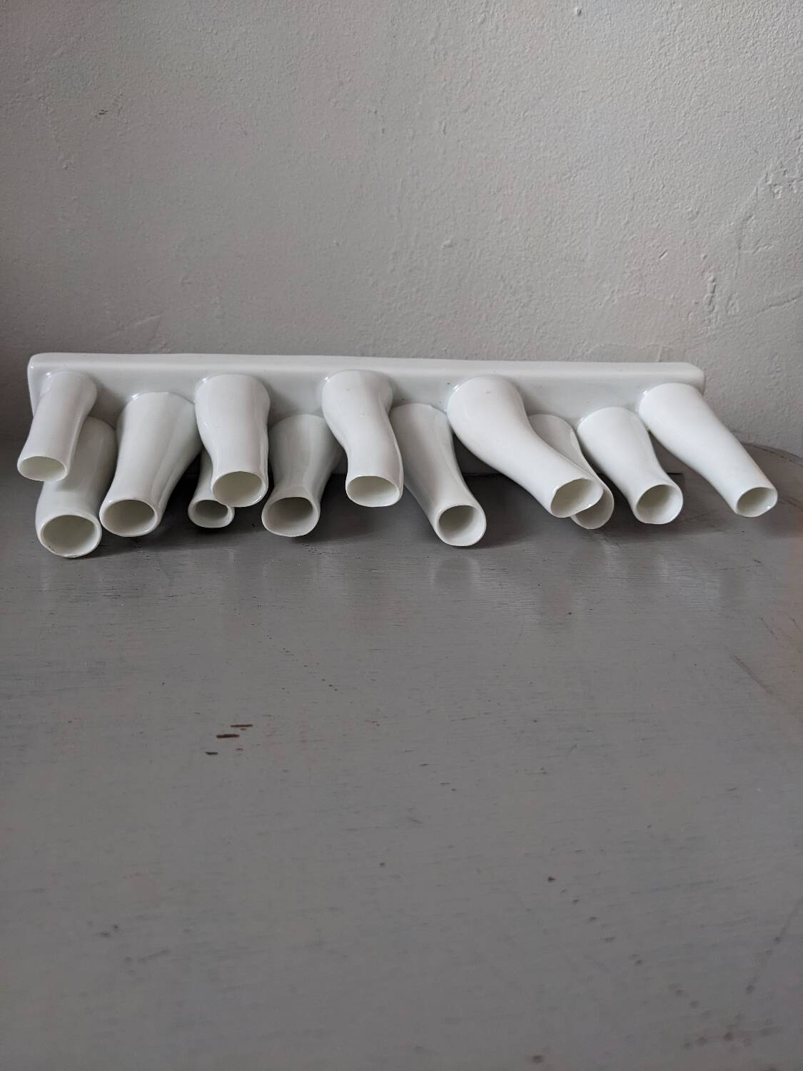 set of decorative vases composed of 11 white ceramic soliflores, evoking the delicate appearance of coral. In good general condition, despite some chips. Dimensions: 29.5 * 5.2 * 11.5 cm.