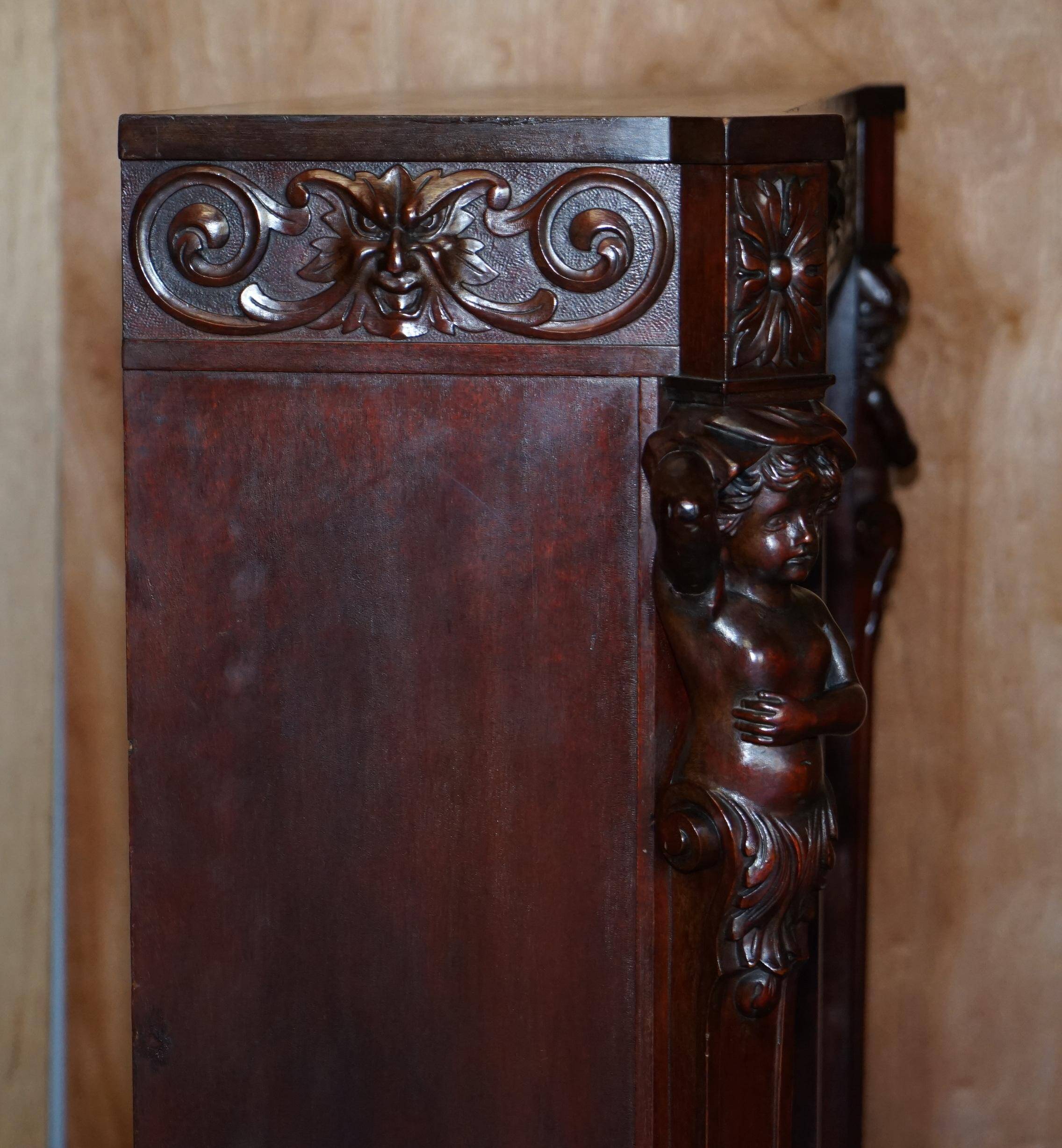 Hand-carved library circa 1900 in hardwood with Hermes statues.