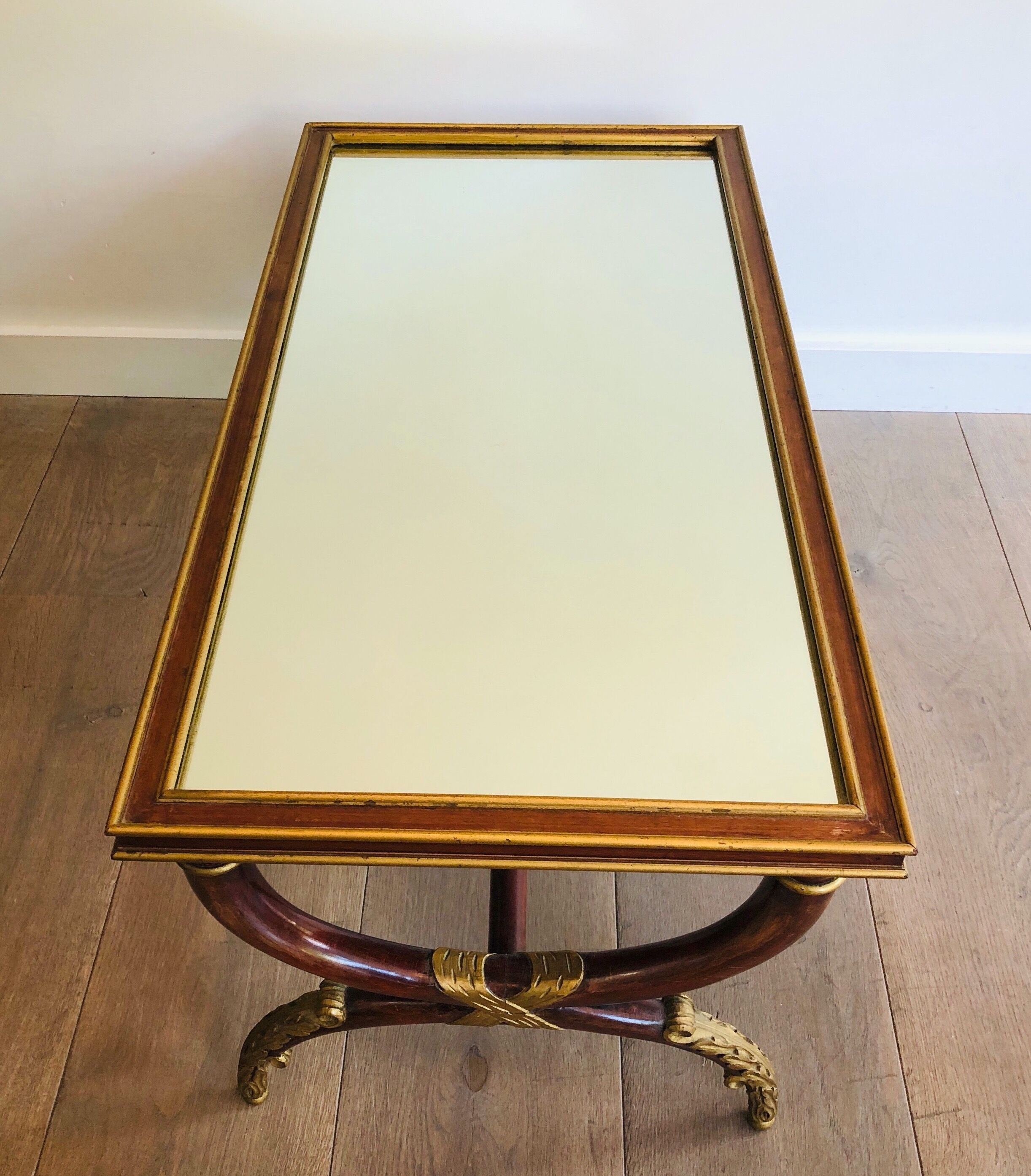 Coffee table in patinated and gilded carved wood with mirror top