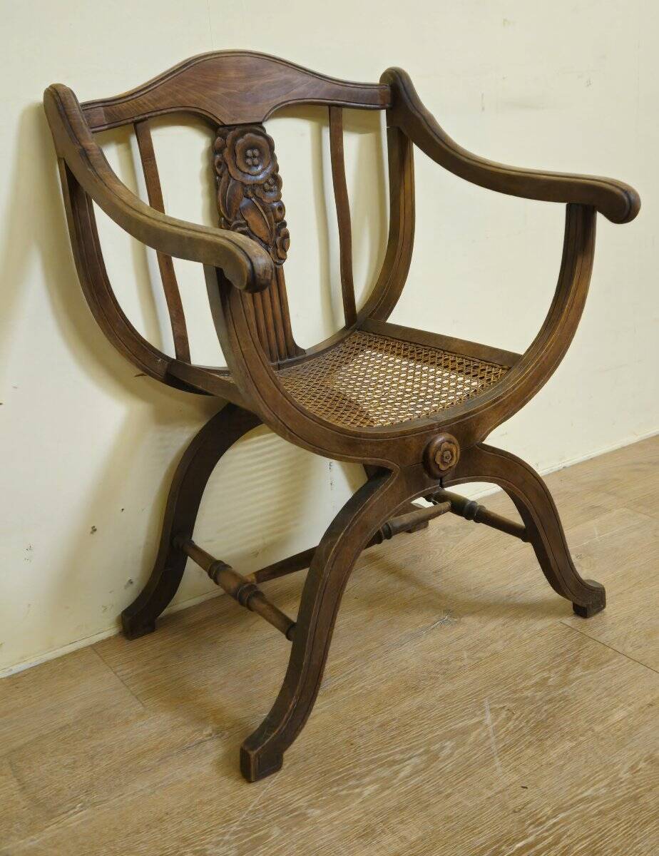 Fauteuil curule de style Art Nouveau en noyer sculpté et assise cannée