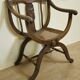 Fauteuil curule de style Art Nouveau en noyer sculpté et assise cannée